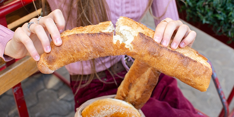 ragazza che spezza una baguette